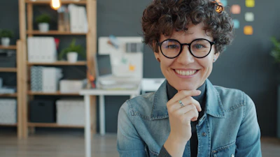 Smiling woman with glasses in an office setting