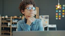 Woman wearing glasses thinking at desk