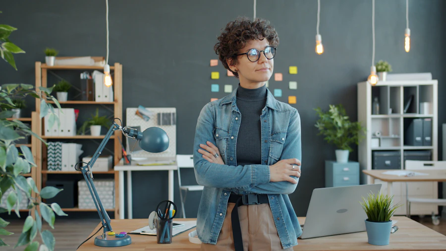 Femme d'affaires debout, bras croisés, dans un bureau moderne.