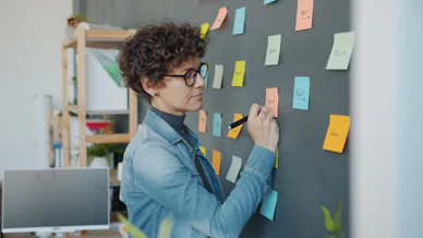 Woman writing on sticky notes on a wall