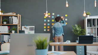 Person arranging sticky notes on a dark wall