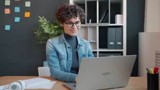 Woman working on a laptop at a desk.