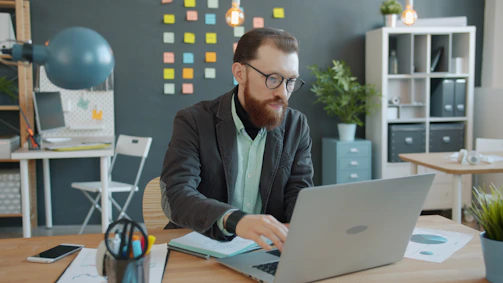 Man working on laptop in a modern office.
