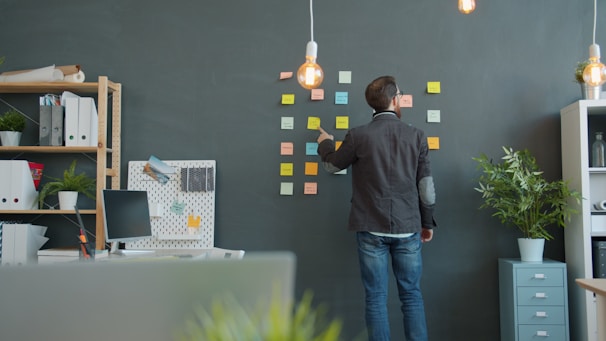Man planning on sticky notes wall in office