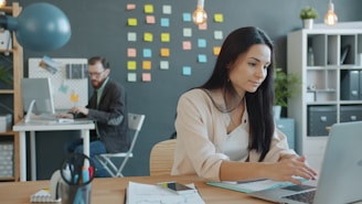 Woman working on a laptop in a modern office.