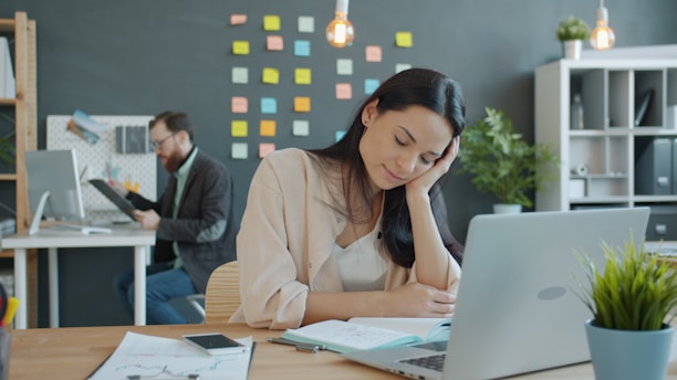 Woman resting head on hand at desk