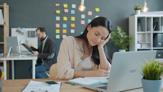 Woman resting head on hand at desk