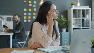 Woman using earbuds in a modern office setting