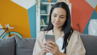 Frau entspannt auf der Couch mit Smartphone – App einrichten