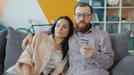 Couple sitting on couch, man holding phone