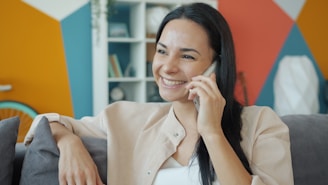 A woman smiling while talking on a cell phone.