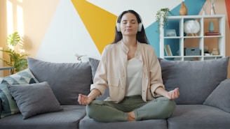 Woman meditating on couch with headphones on