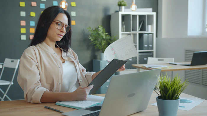 Registrar staff member reviewing documents at an office desk