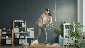Woman dancing on desk with headphones on