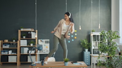 Woman dancing on desk with headphones on