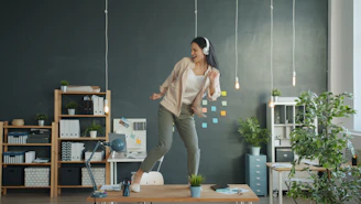 Woman dancing on desk with headphones on