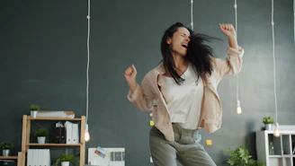 A woman joyfully dancing with arms raised.