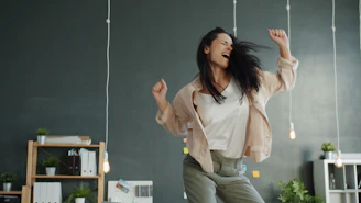 A woman joyfully dancing with arms raised