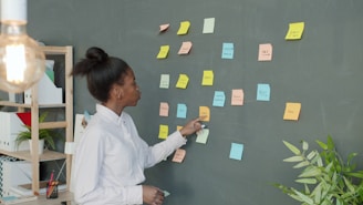 Woman points at colorful sticky notes on wall