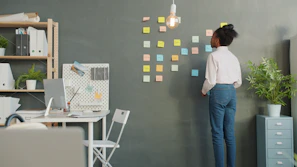 Woman adding colorful sticky notes to a wall