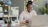 Woman smiling while working on a laptop at a desk.