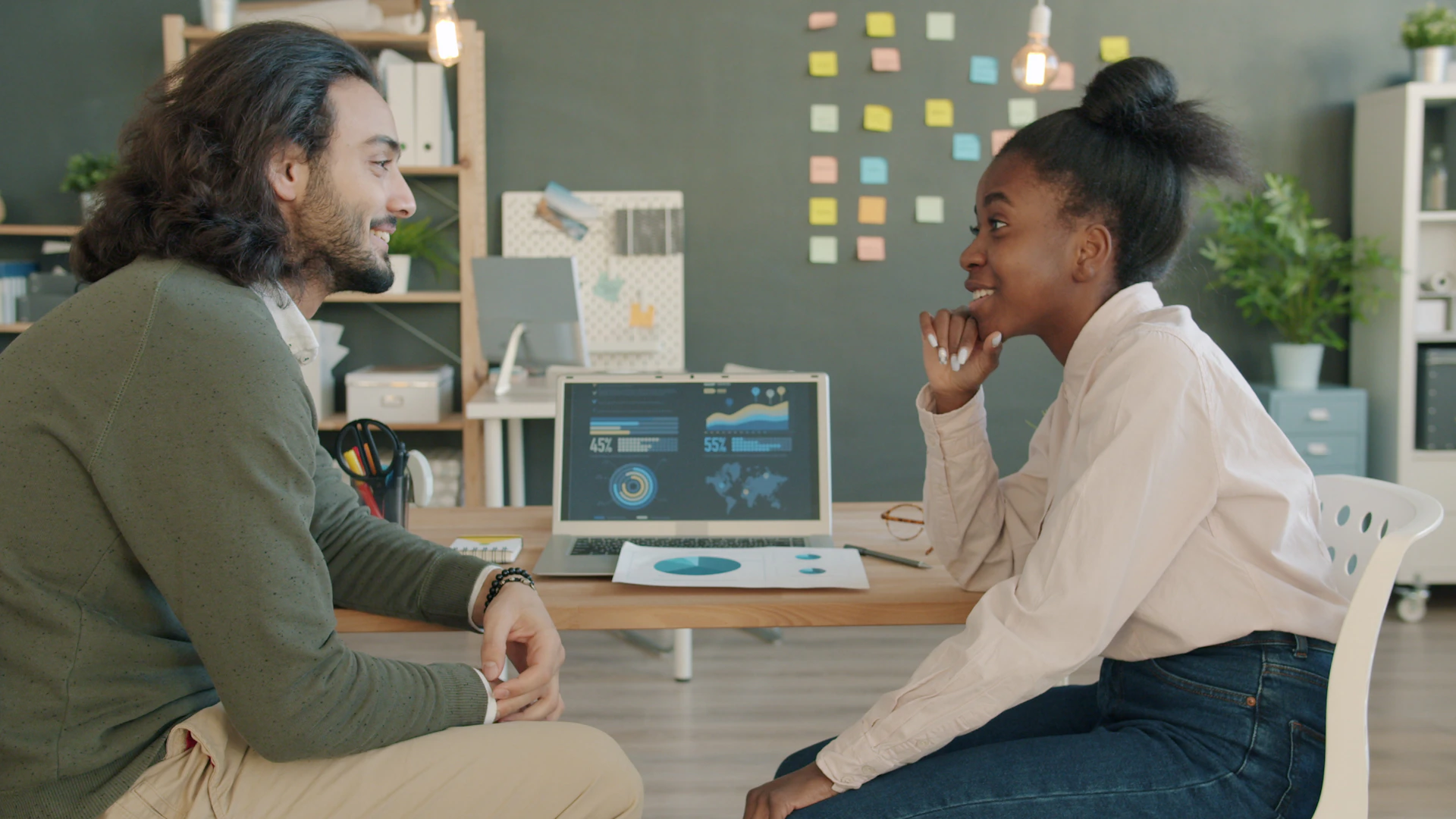 Two colleagues discussing work at a desk.