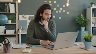 Man working on laptop in modern office space.