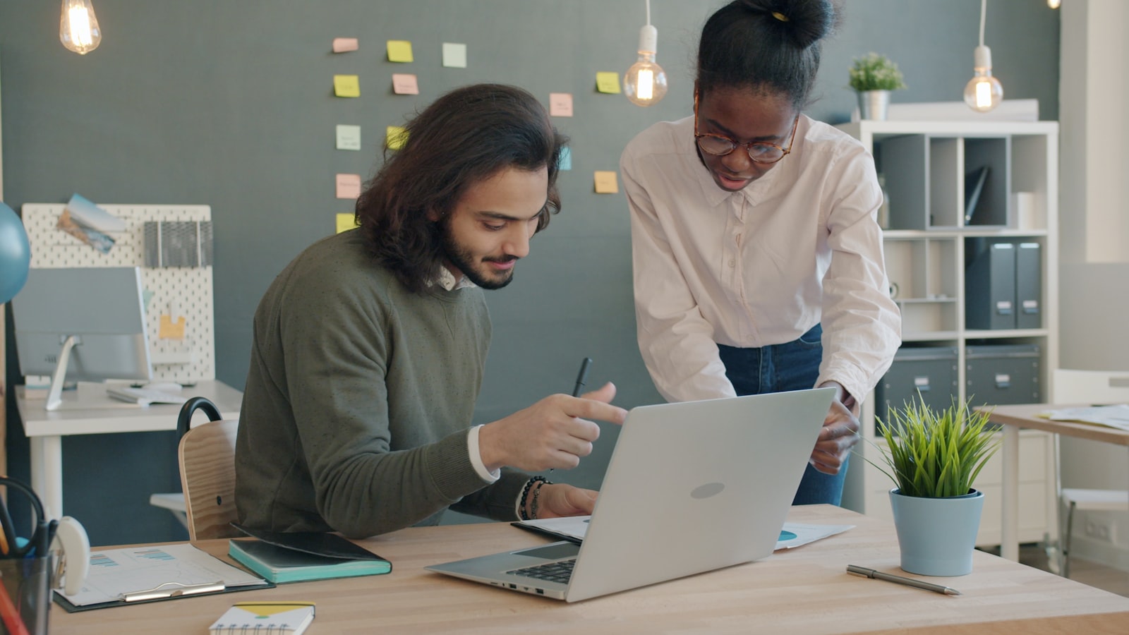 Two colleagues collaborating on a laptop in an office