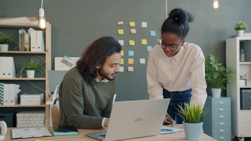 Two colleagues collaborating on a project at a desk.