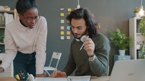 Two colleagues collaborating at a desk in an office.