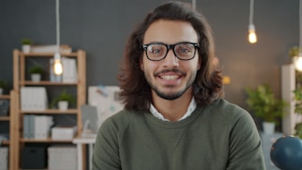 Man with glasses and long hair smiling