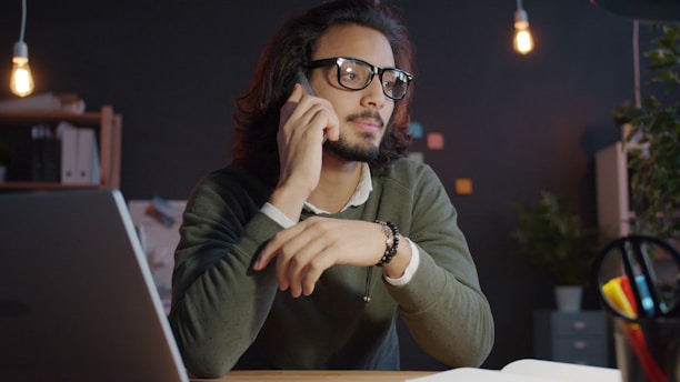 Man talking on the phone at a desk.