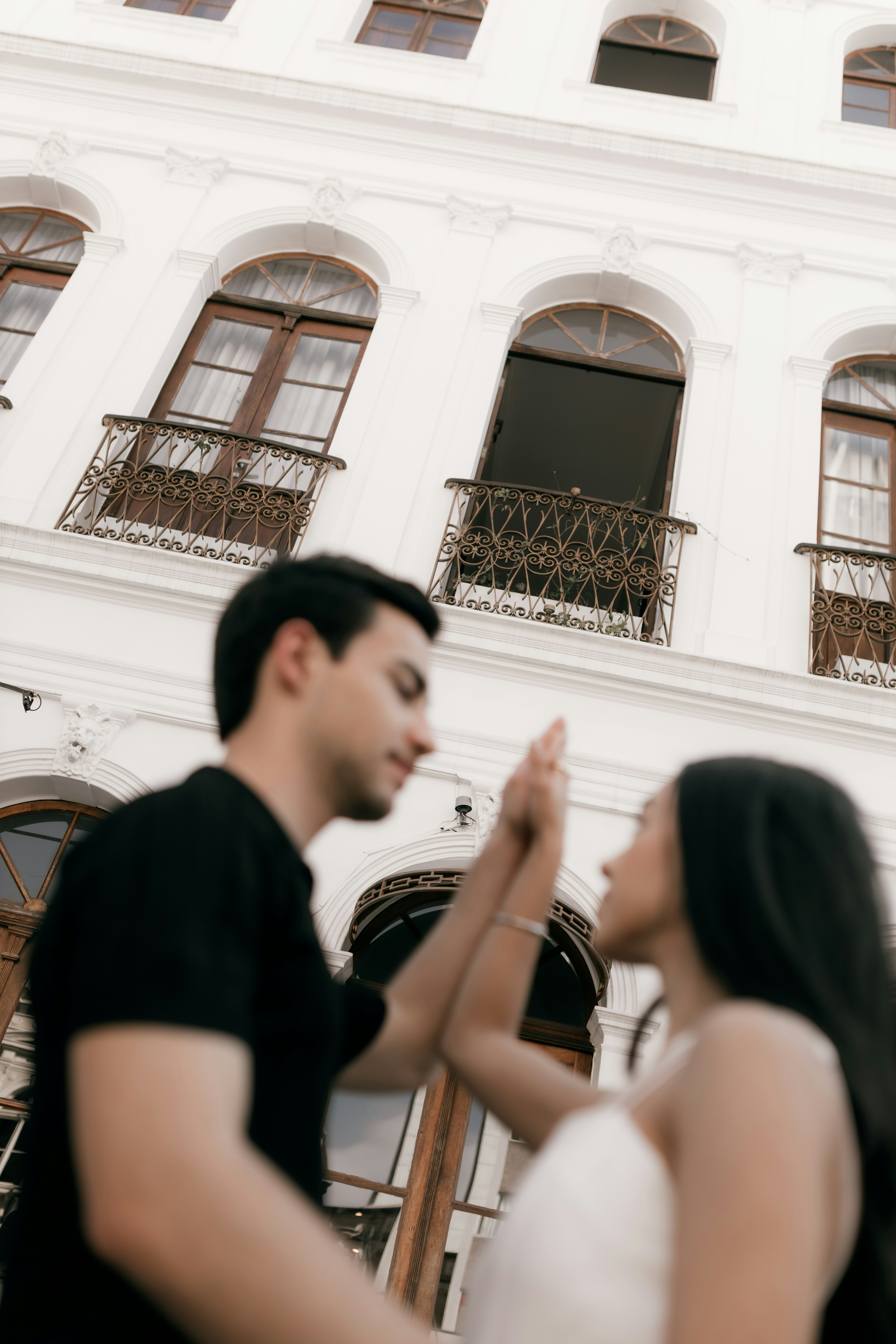 Couple posing in front of a white building