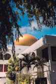 Golden dome of a mosque against a blue sky.