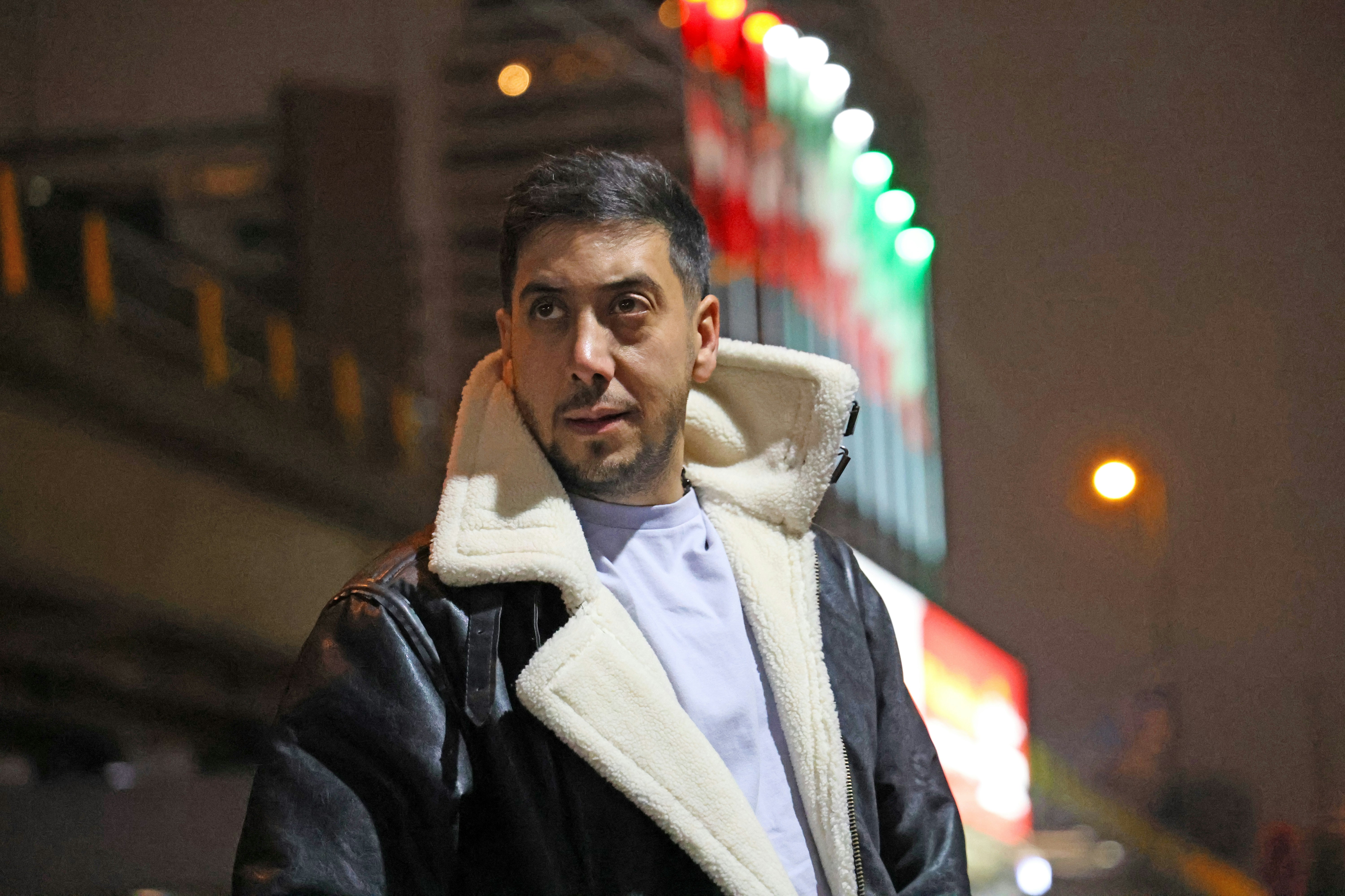 Man in a shearling-lined jacket at night