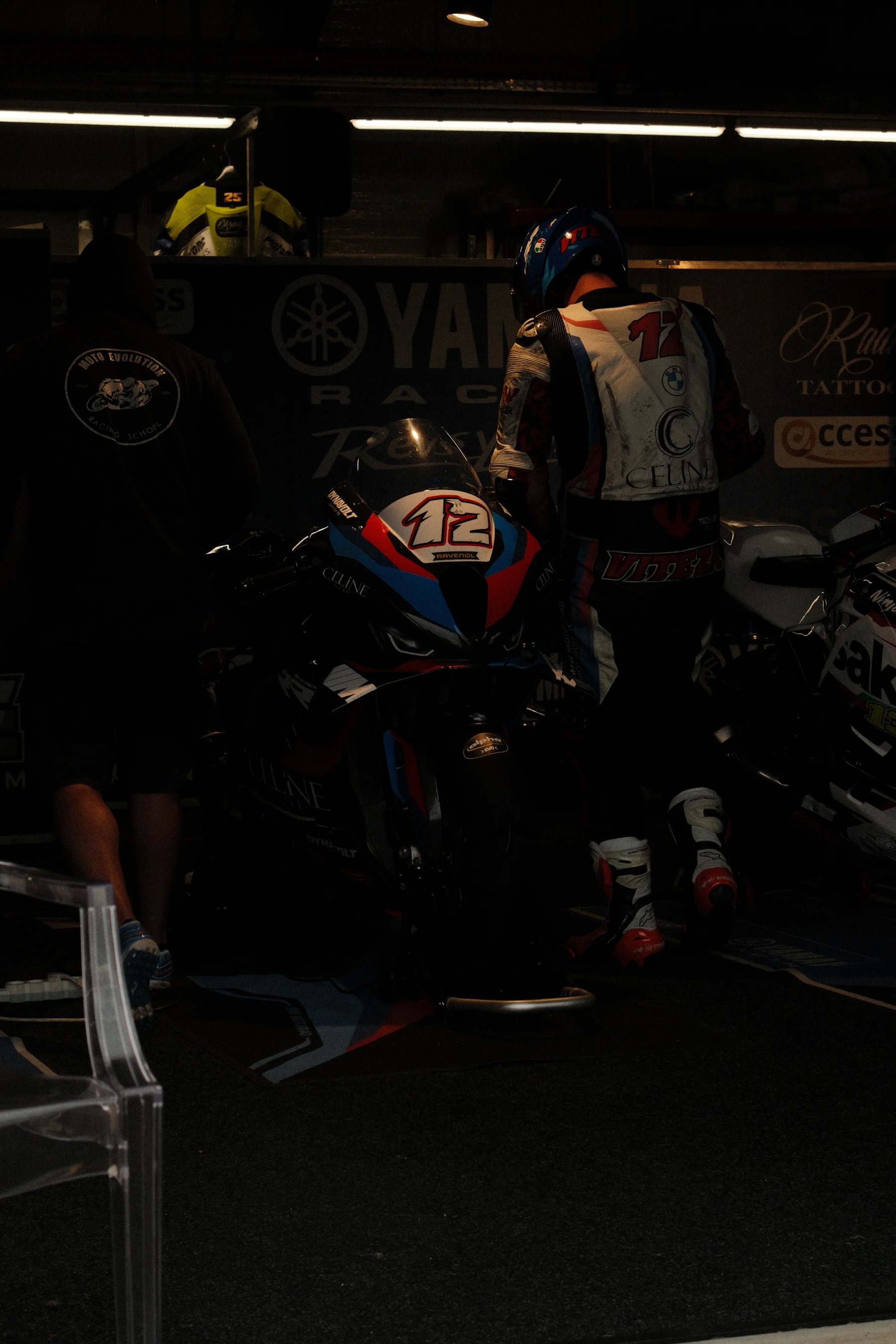 Performance motorcycle rider and motorcycle in a dark technical garage environment