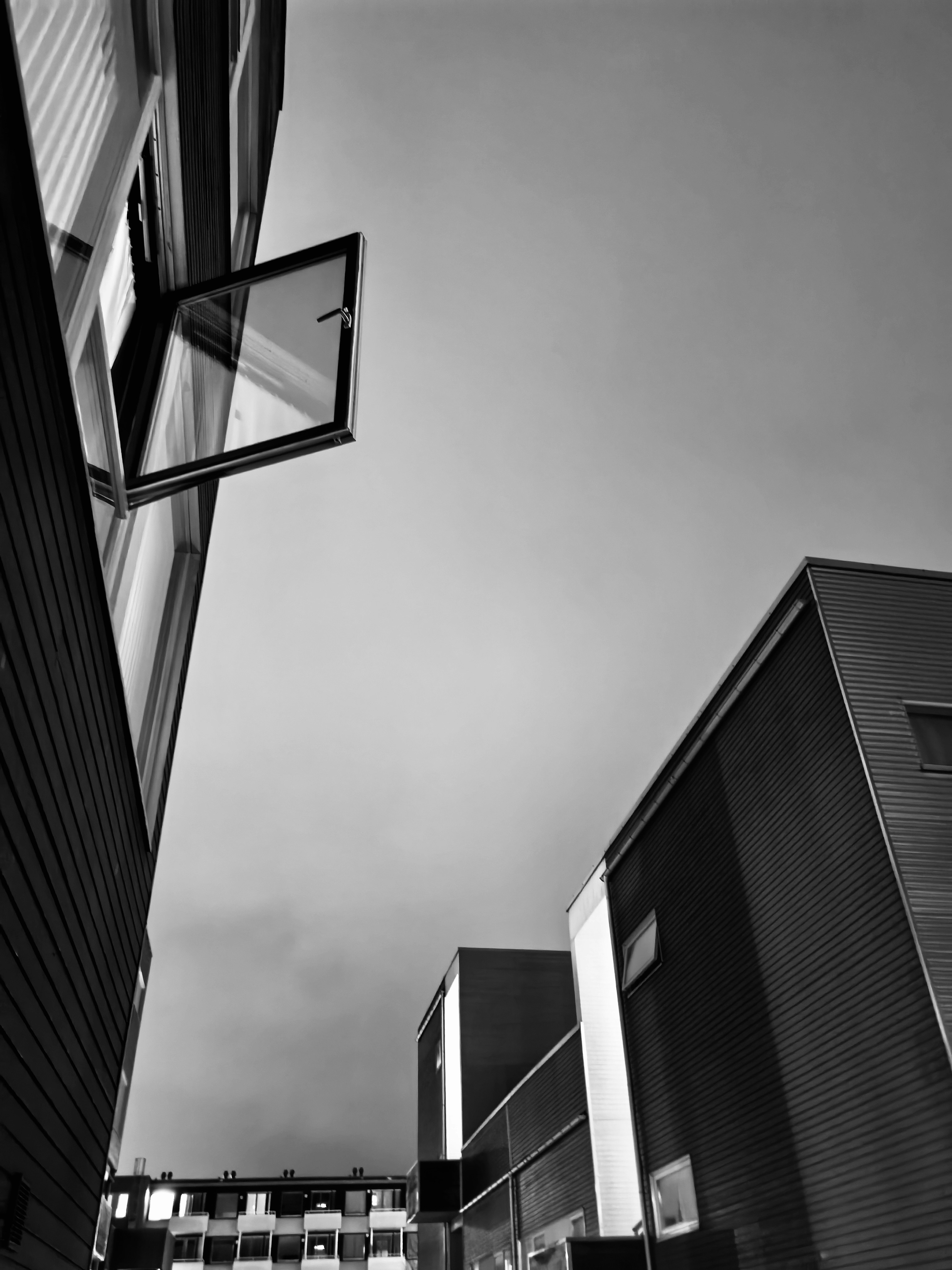 Modern buildings with open window against sky