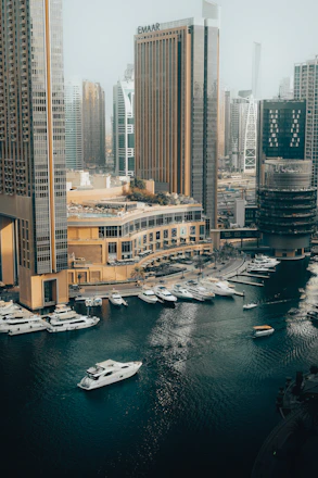 Modern cityscape with yachts docked in a marina canal.