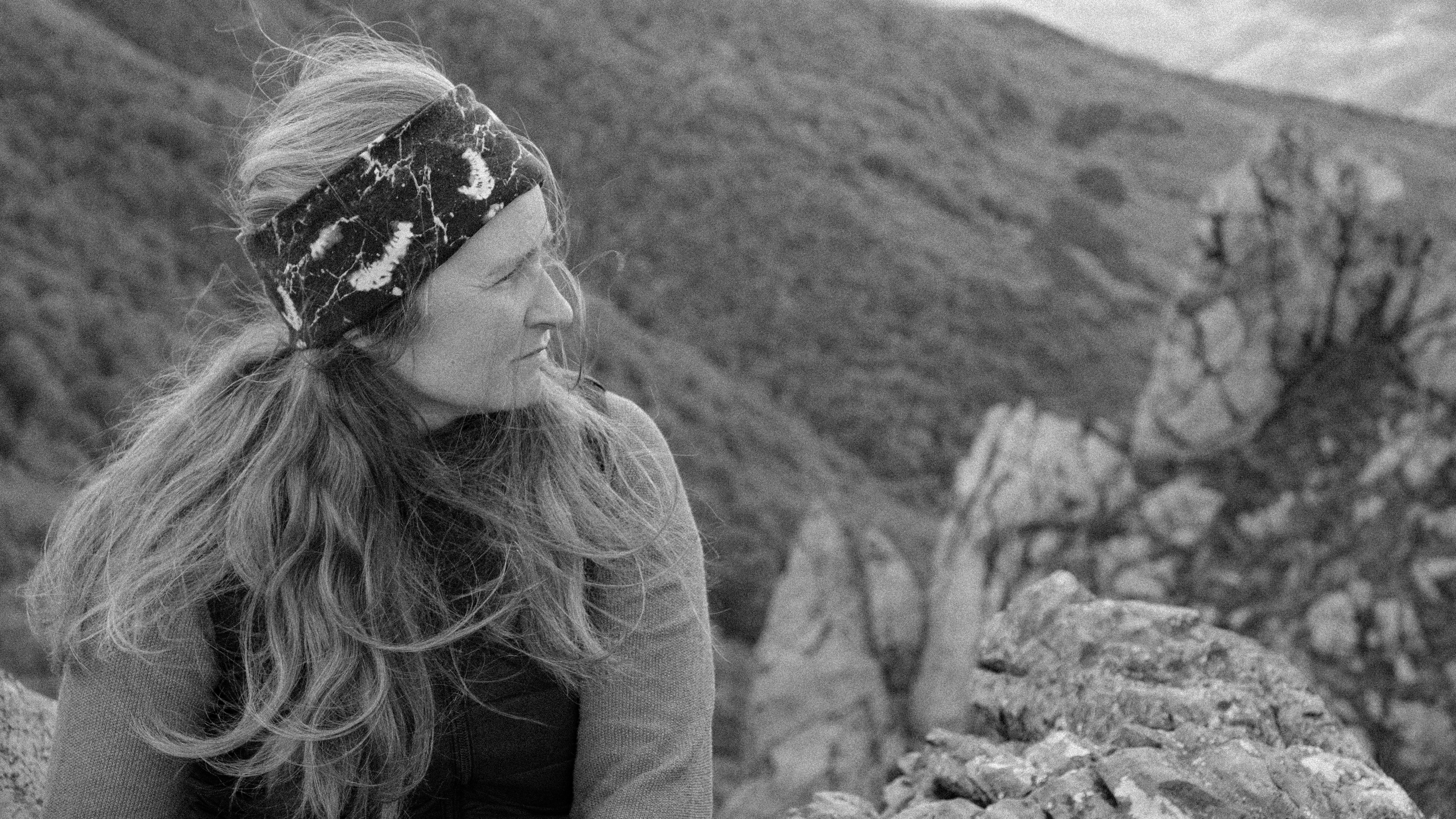 긴 금발 머리와 머리띠를 착용한 여성 산에서