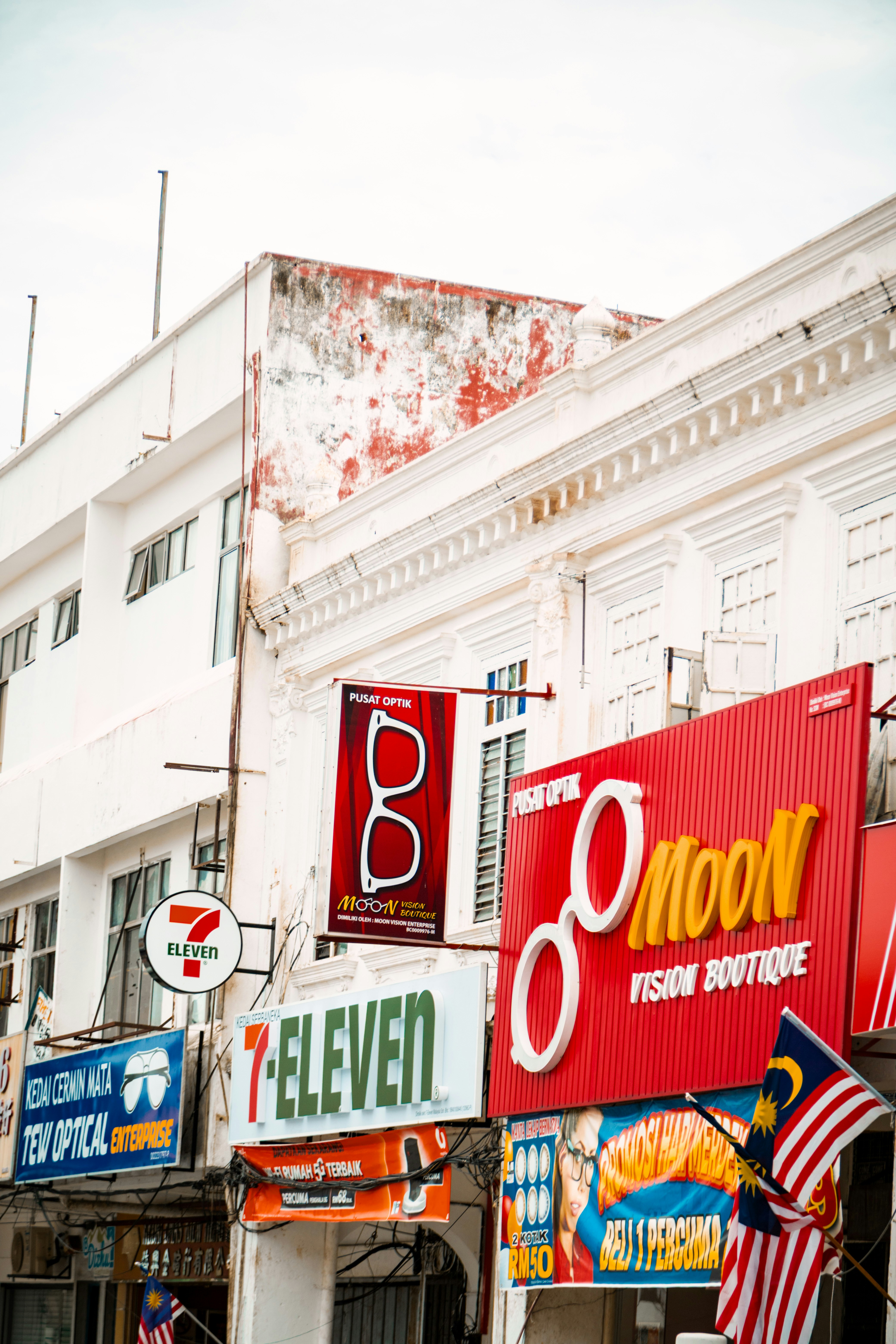 Shops with signs for 7-eleven and moon vision boutique.