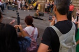 Crowd watches a performer on a street.
