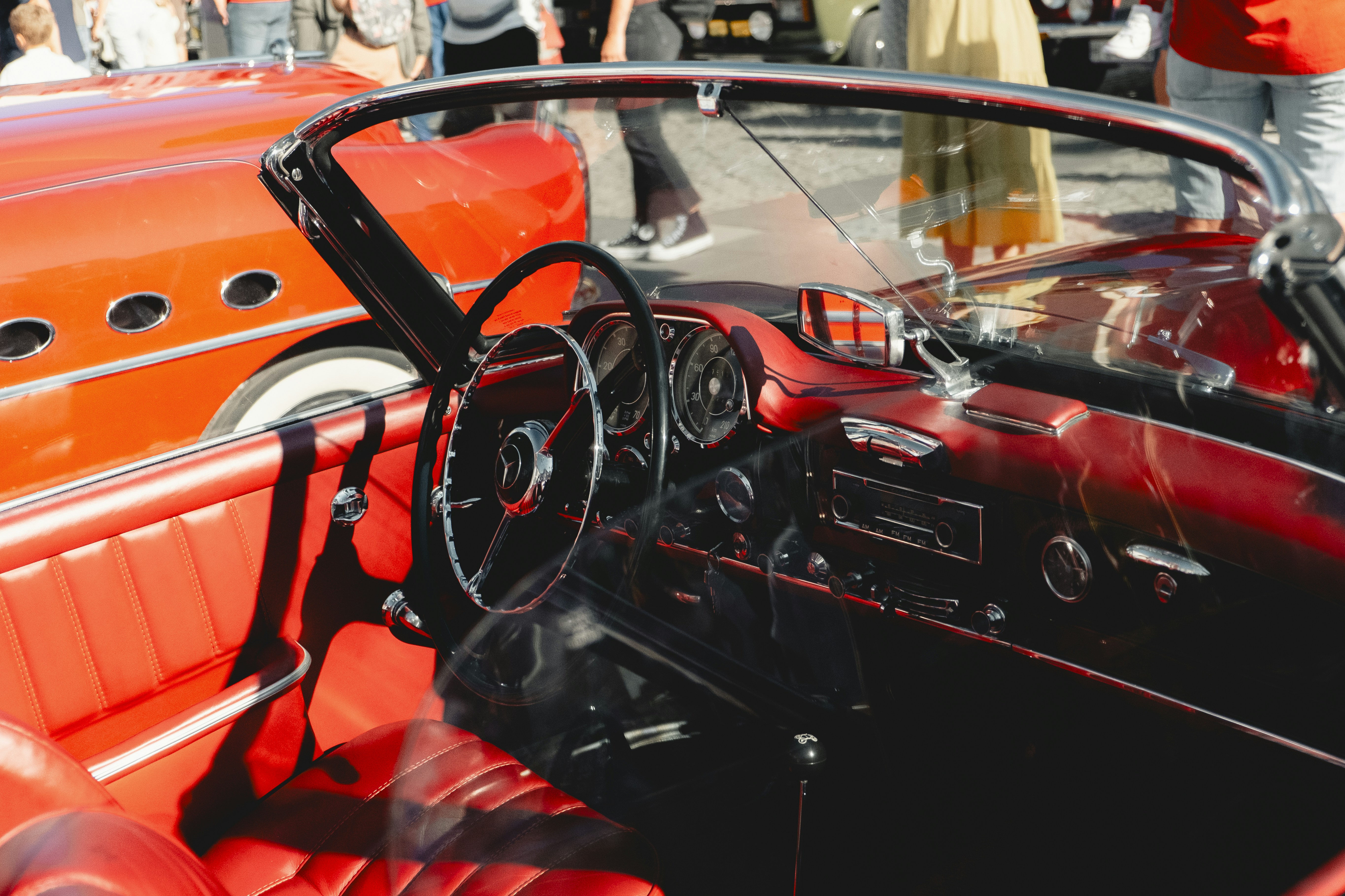 Red vintage car interior with dashboard and steering wheel.