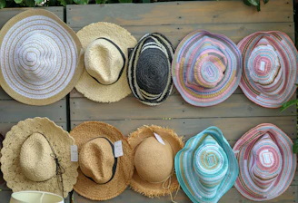 Collection of straw hats displayed on a wooden wall.