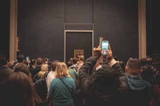Crowd taking photos of mona lisa painting in museum