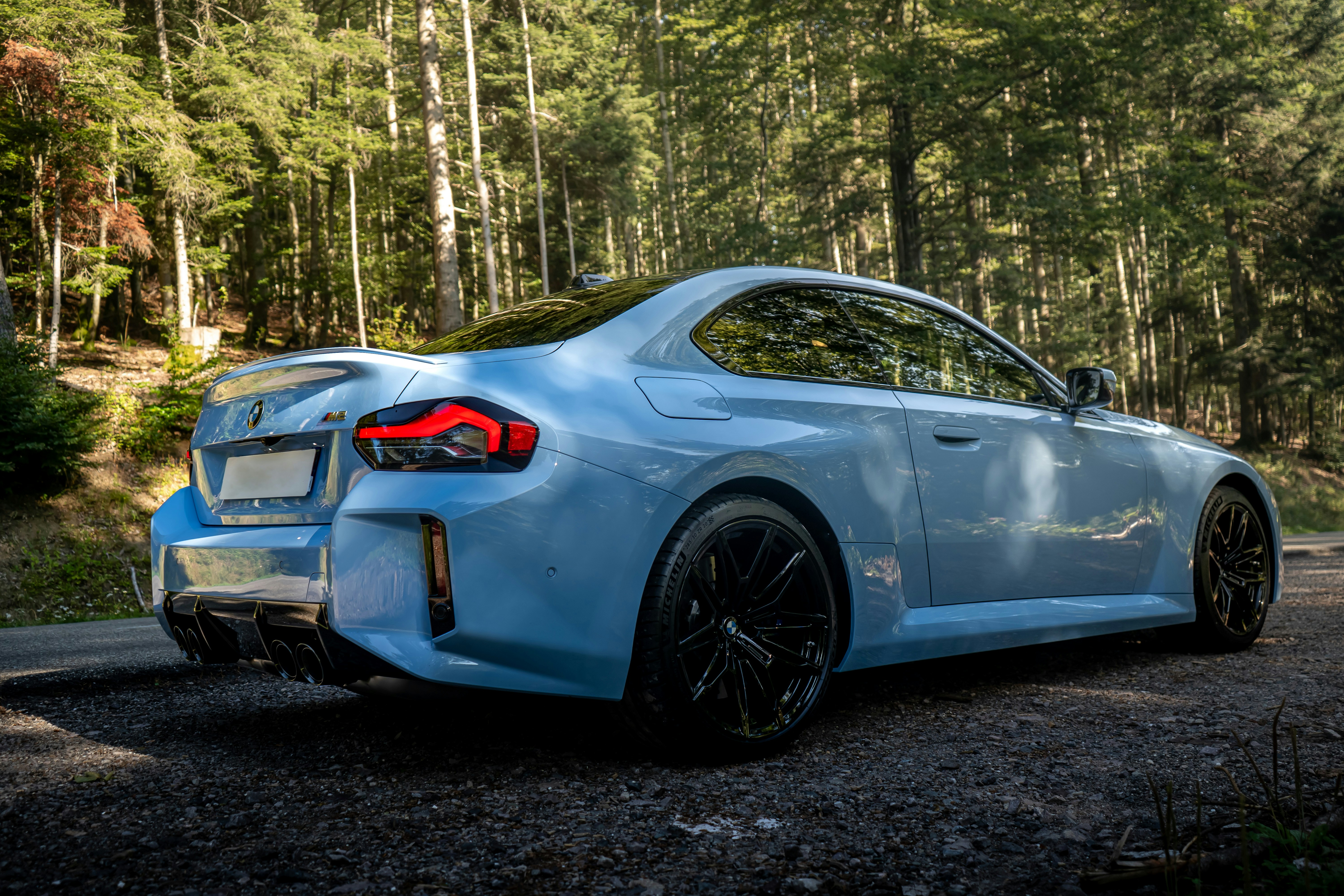 Mobil sport biru muda diparkir di hutan