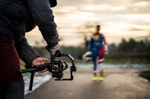 Filming a person with a camera gimbal outdoors.