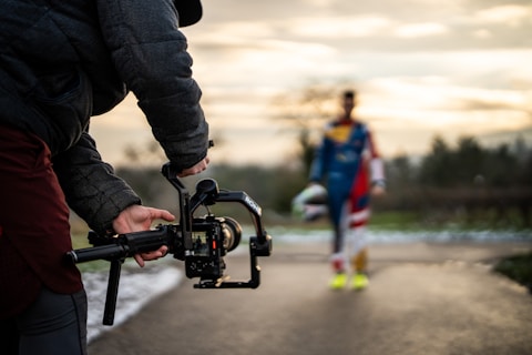 Filming a person with a camera gimbal outdoors.