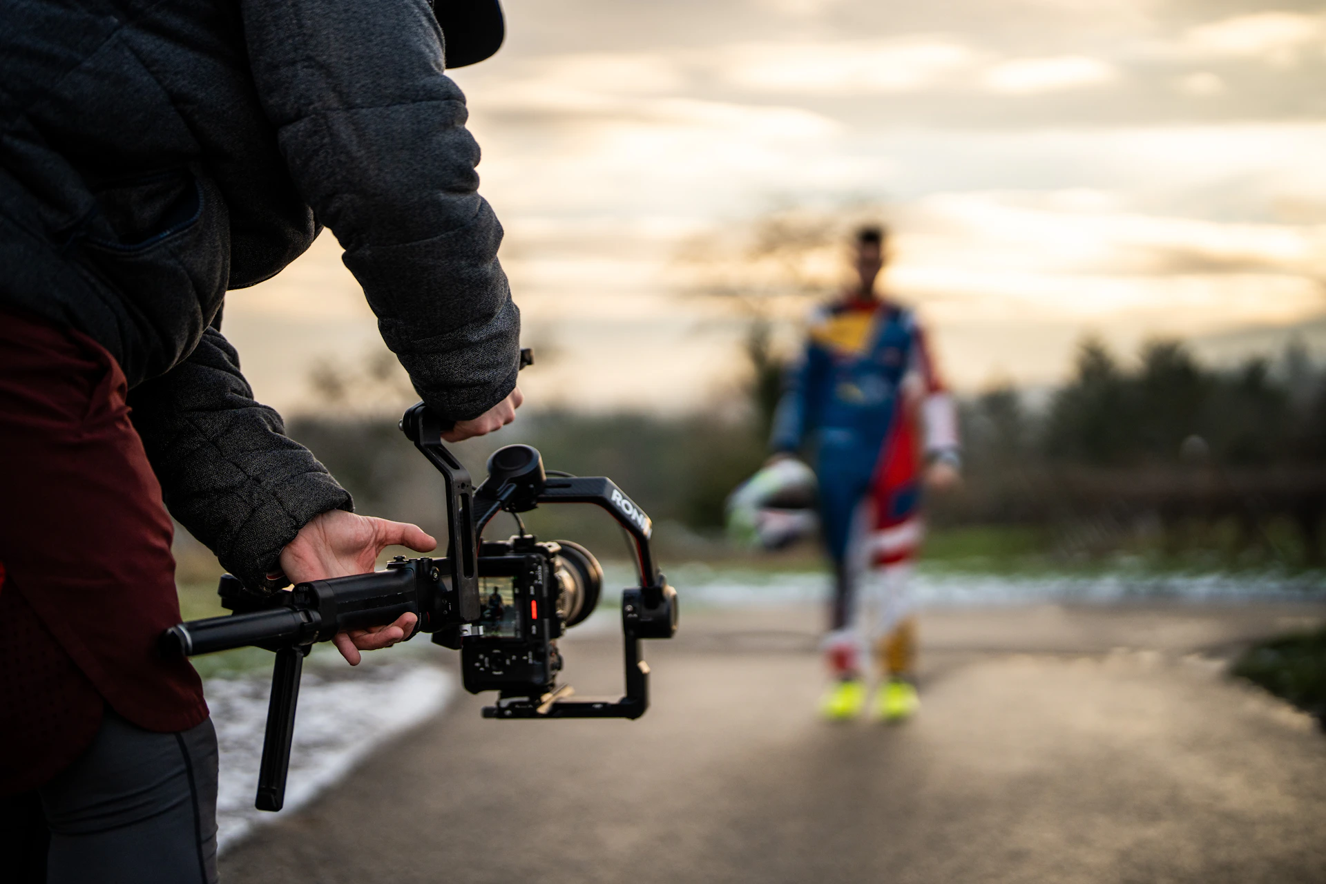 Filming a person with a camera gimbal outdoors.