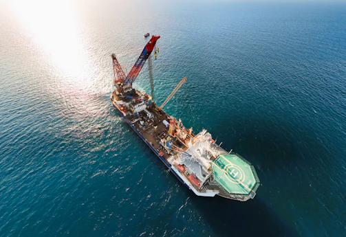 A large construction vessel with a crane at sea
