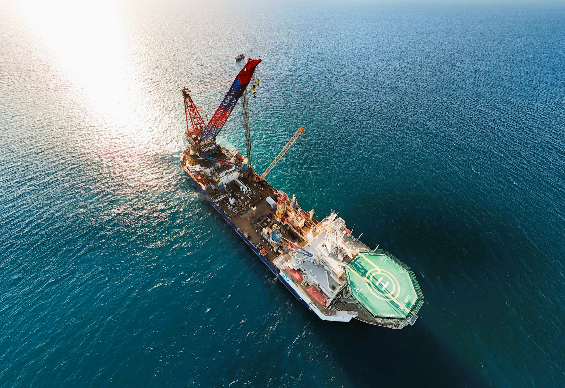 A large construction vessel with a crane at sea